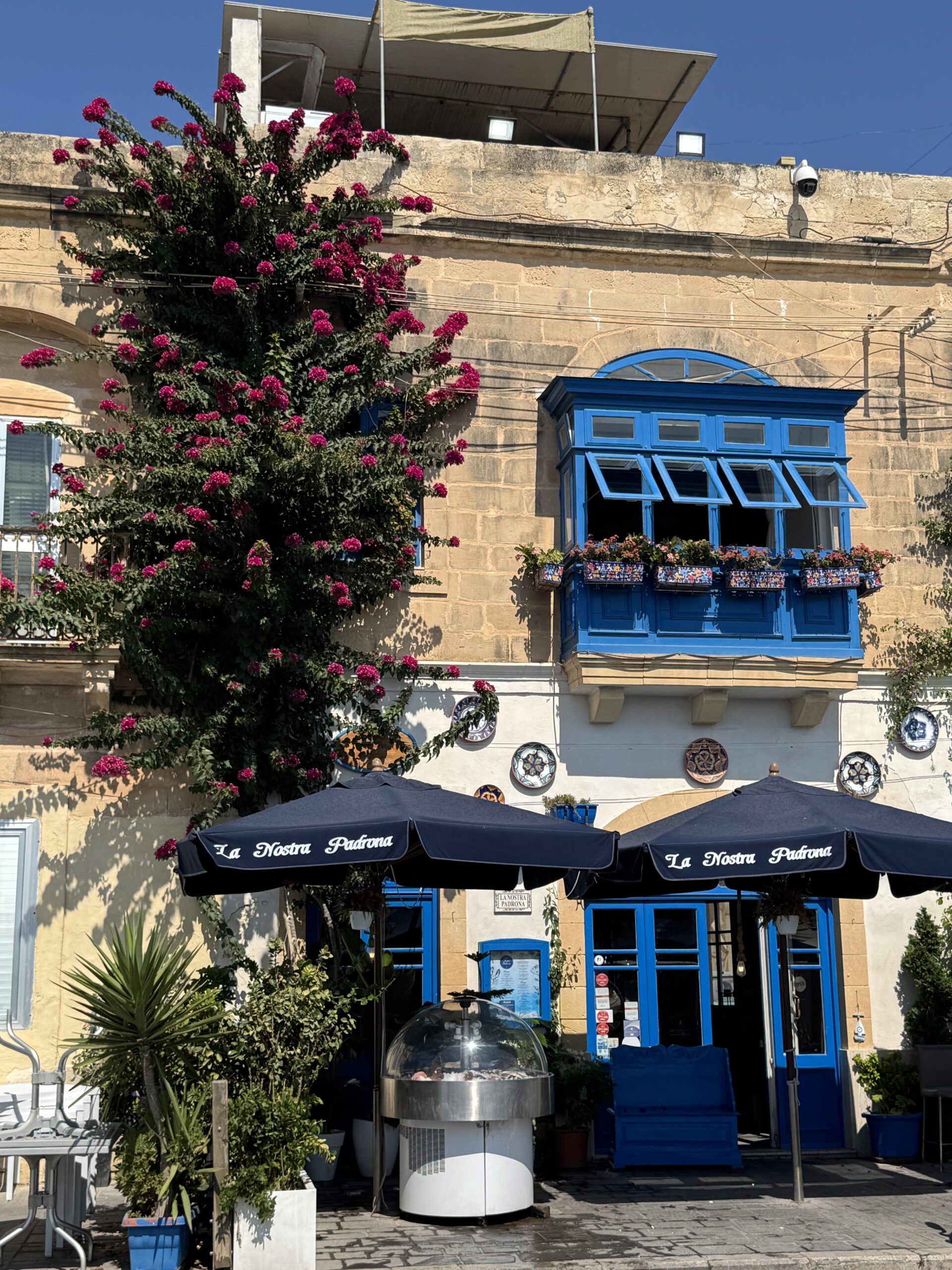 Historic stone architecture with blue enclosed balconies, inspiring timeless interior design details.