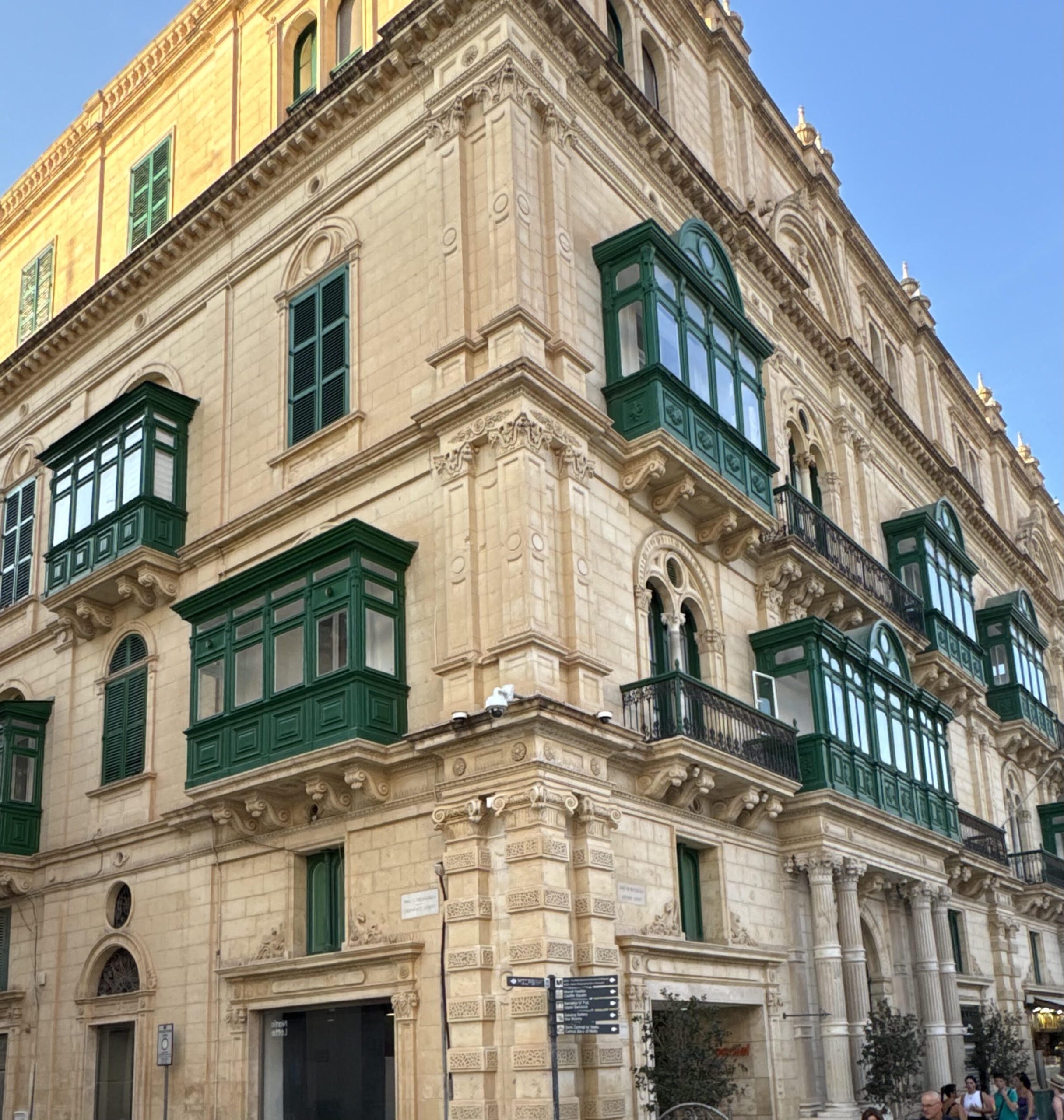 Historic stone architecture with green enclosed balconies, inspiring timeless interior design details.